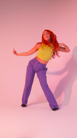 Full-Length-Vertical-Video-Studio-Shot-Of-Woman-Dancing-Against-Pink-Background